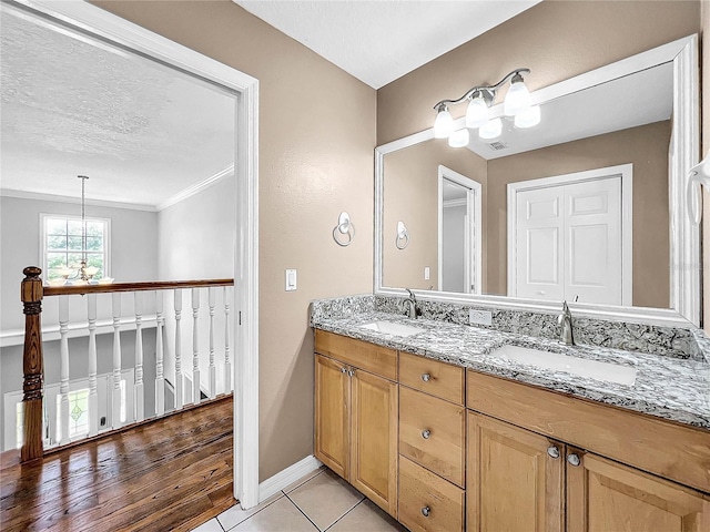 bathroom with tile patterned flooring, vanity, a textured ceiling, and a chandelier