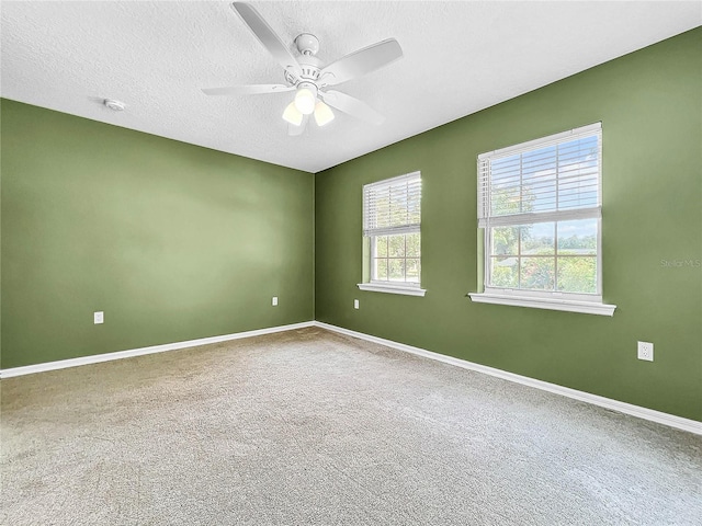 empty room featuring ceiling fan, carpet floors, and a textured ceiling