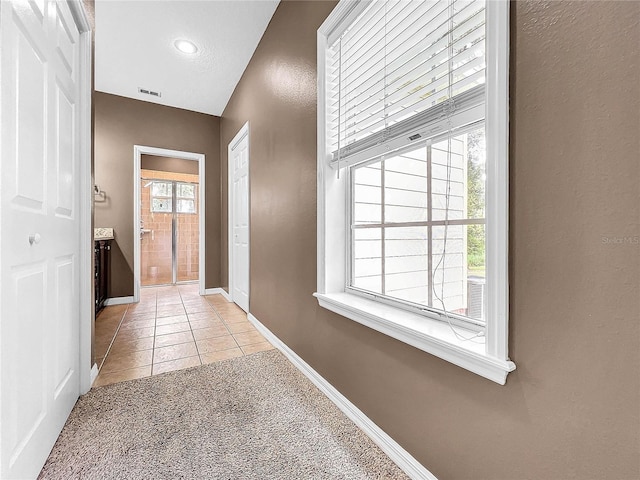 hall with light colored carpet