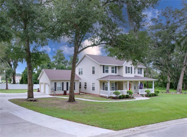 view of front facade with a garage, a lawn, and a porch