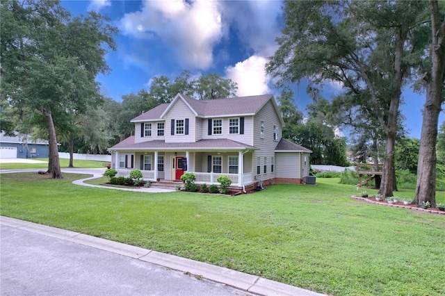 colonial inspired home featuring a porch and a front yard