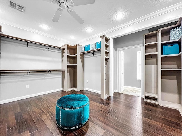 walk in closet featuring dark wood-type flooring and ceiling fan