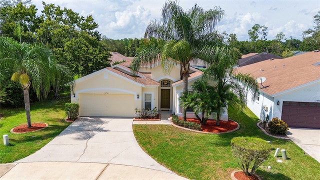 mediterranean / spanish home featuring a garage and a front lawn