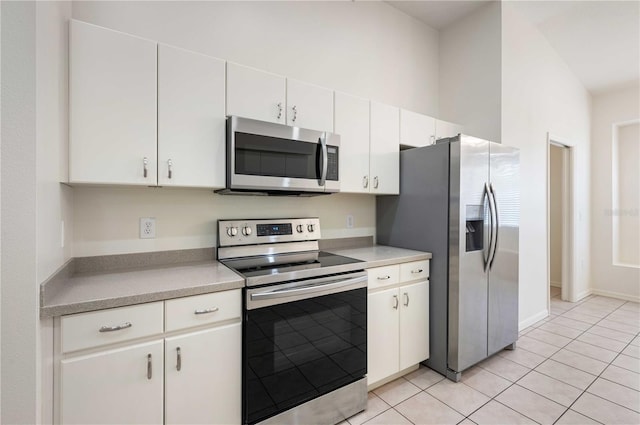 kitchen with white cabinets, stainless steel appliances, and light tile patterned floors