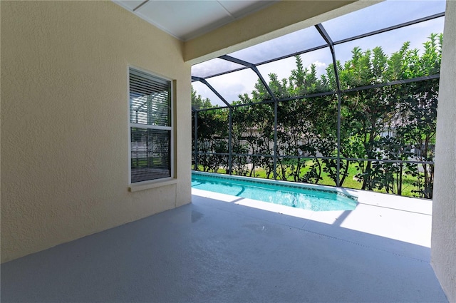 view of swimming pool with glass enclosure and a patio