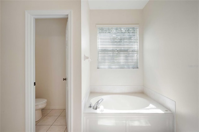 bathroom with toilet, tile patterned floors, and a bathtub