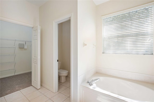 bathroom featuring toilet, tile patterned floors, and a washtub