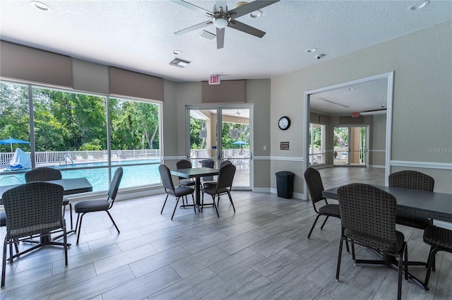 dining space with a textured ceiling and ceiling fan