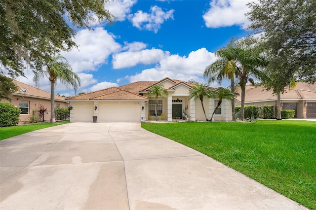 mediterranean / spanish-style house with a garage and a front lawn