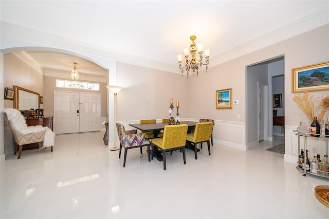 tiled dining room with crown molding and a chandelier