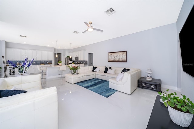 living room featuring light tile patterned floors and ceiling fan