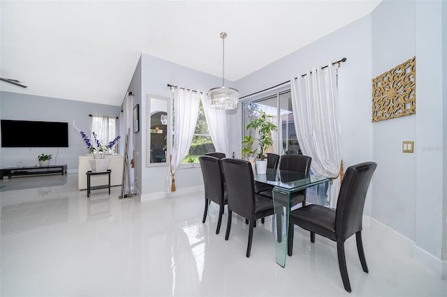 tiled dining space with an inviting chandelier, lofted ceiling, and plenty of natural light