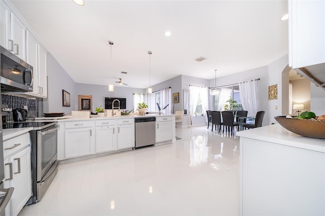 kitchen featuring hanging light fixtures, stainless steel appliances, and white cabinets