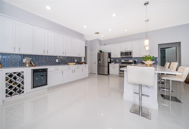 kitchen with pendant lighting, a breakfast bar, white cabinetry, stainless steel appliances, and wine cooler