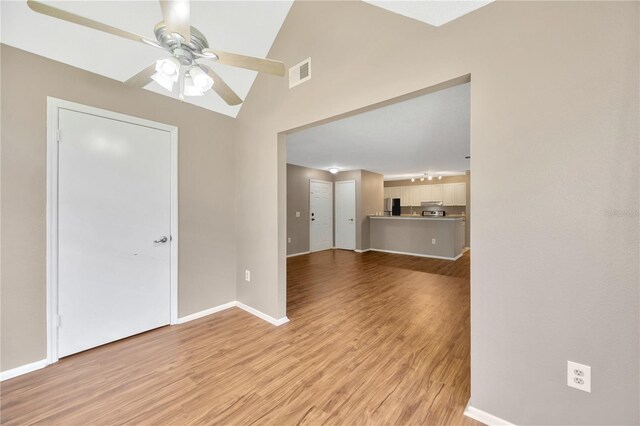 spare room featuring light hardwood / wood-style flooring, ceiling fan, and vaulted ceiling