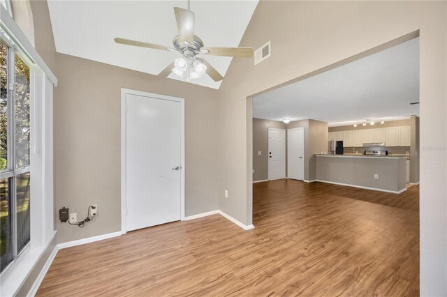 unfurnished living room with light hardwood / wood-style flooring, high vaulted ceiling, and ceiling fan