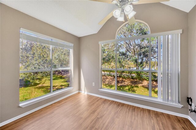 interior space with ceiling fan, vaulted ceiling, plenty of natural light, and hardwood / wood-style floors