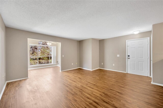 empty room featuring a textured ceiling and wood-type flooring