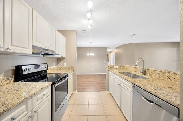 kitchen featuring white cabinets, hanging light fixtures, appliances with stainless steel finishes, light hardwood / wood-style floors, and sink