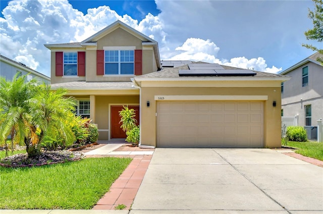 view of front of house with driveway, solar panels, an attached garage, central air condition unit, and stucco siding