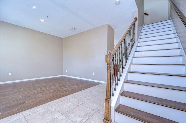 stairway with baseboards, wood finished floors, and recessed lighting