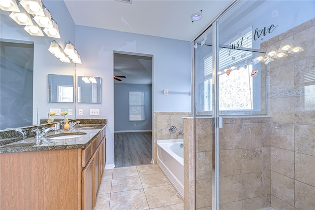 full bath with double vanity, a garden tub, tile patterned flooring, a shower stall, and a sink