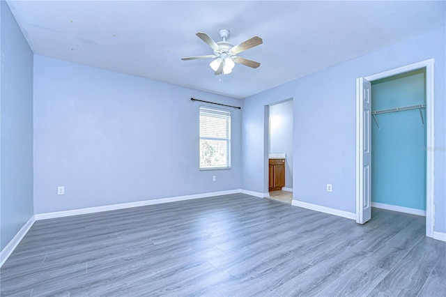 unfurnished bedroom with a closet, baseboards, and dark wood-style flooring