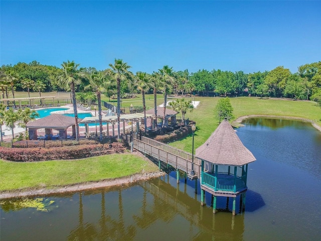 dock area featuring a water view, a lawn, and a community pool