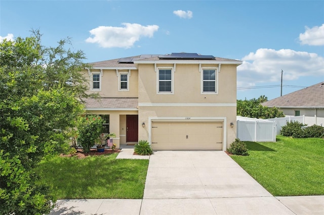 view of front of property featuring a front lawn, solar panels, and a garage