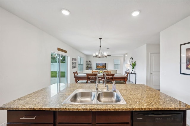 kitchen with dishwasher, a notable chandelier, a center island with sink, sink, and dark brown cabinets