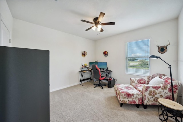 carpeted home office featuring ceiling fan