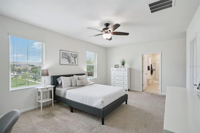 carpeted bedroom with ceiling fan and connected bathroom