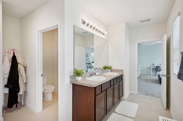 bathroom featuring toilet, vanity, and tile patterned flooring