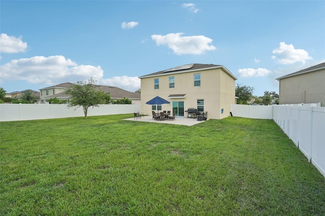 rear view of property with a lawn and a patio