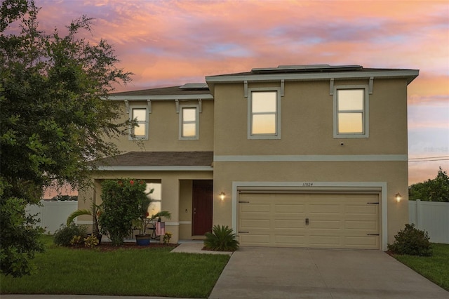 view of front of home with a lawn, solar panels, and a garage