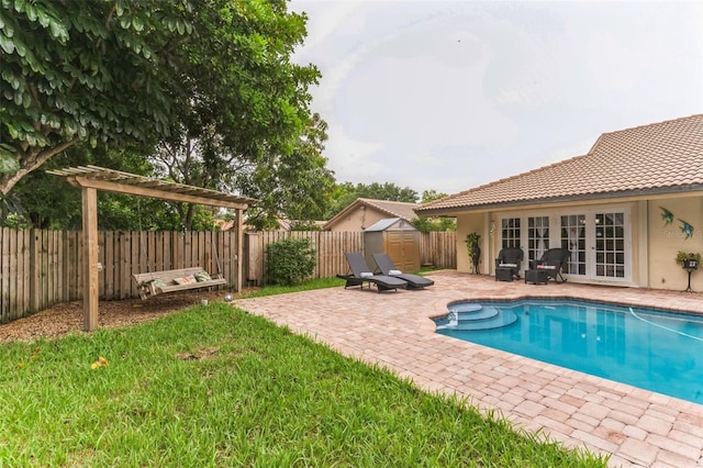 view of swimming pool featuring a storage unit, a patio, and a lawn