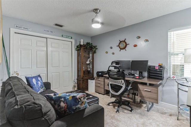 carpeted office with ceiling fan and a textured ceiling