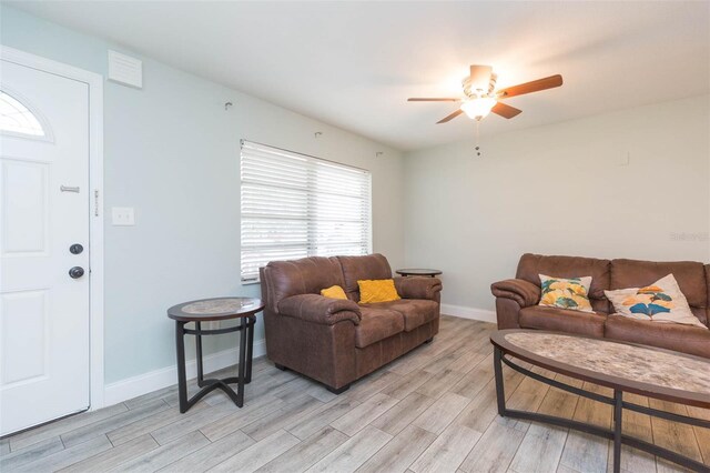 living room featuring light hardwood / wood-style flooring and ceiling fan