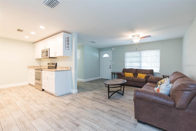 living room featuring light hardwood / wood-style floors and ceiling fan