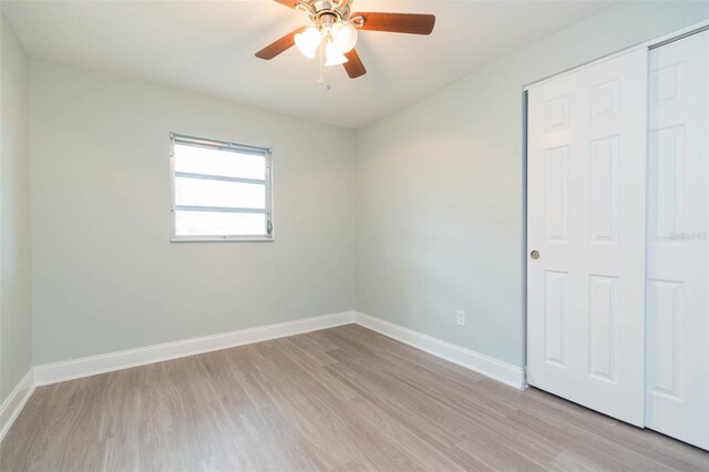 unfurnished bedroom with light hardwood / wood-style flooring, a closet, and ceiling fan