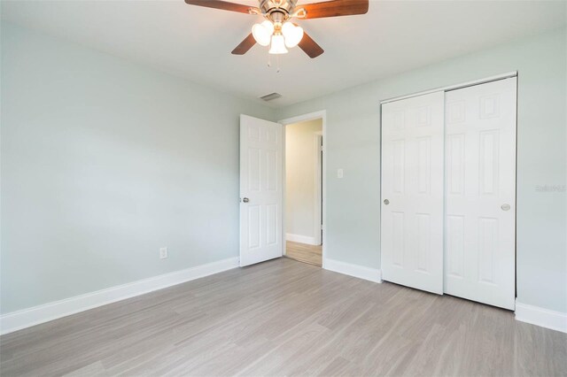 unfurnished bedroom with ceiling fan, hardwood / wood-style flooring, and a closet