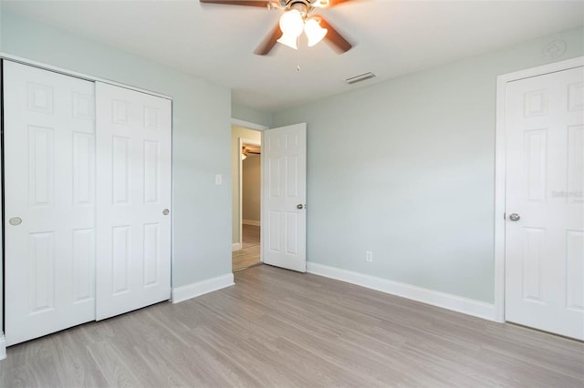 unfurnished bedroom with ceiling fan, light hardwood / wood-style floors, and a closet