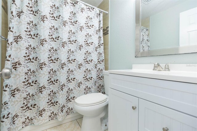 bathroom featuring vanity, tile patterned flooring, and toilet