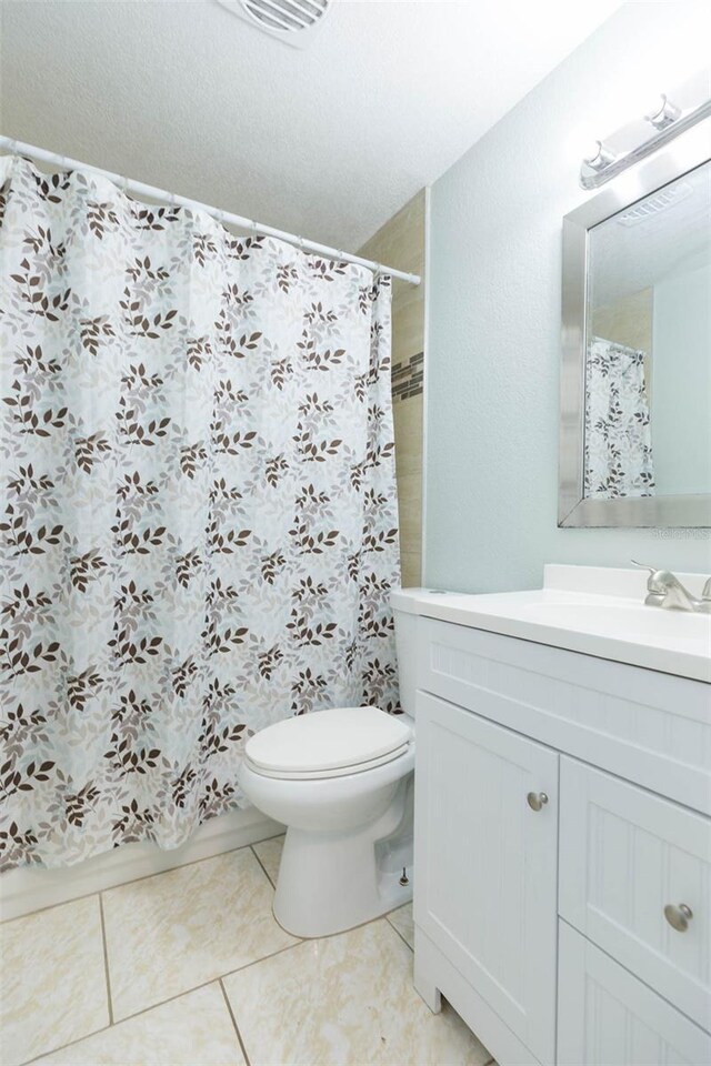 bathroom featuring vanity, toilet, and tile patterned floors