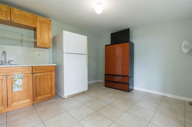 kitchen with sink, white fridge, and light tile patterned floors