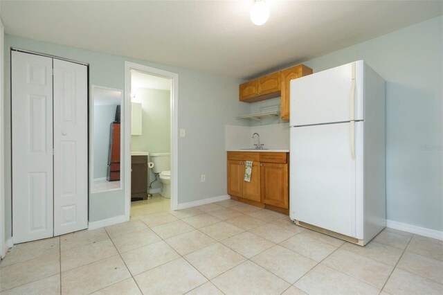 kitchen featuring sink, white refrigerator, and light tile patterned floors