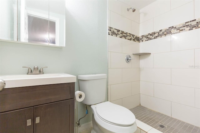 bathroom featuring vanity, tiled shower, and toilet