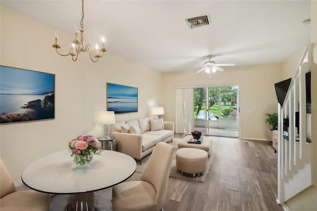 living room with ceiling fan with notable chandelier and hardwood / wood-style floors