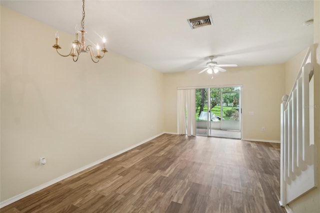 empty room with ceiling fan with notable chandelier and hardwood / wood-style floors