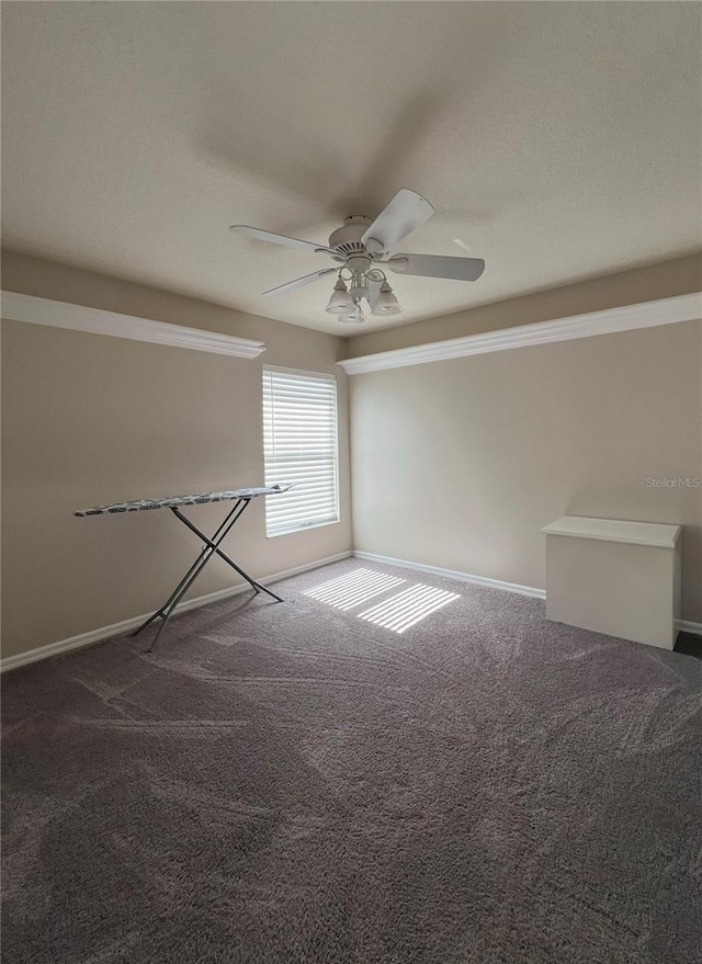 empty room featuring ceiling fan and dark carpet